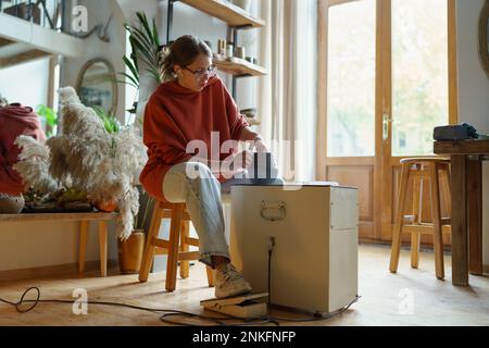 Töpferkünstlerin Frau aus Keramikladen, die in einer modernen Werkstatt formende Lehmvase oder Gläser herstellt. Stockfoto