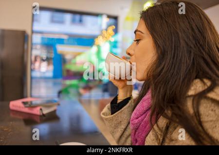 Junge Frau trinken Kaffee im café Stockfoto