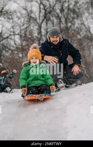 Schlittenfahrer auf einem schneebedeckten Hügel Stockfoto