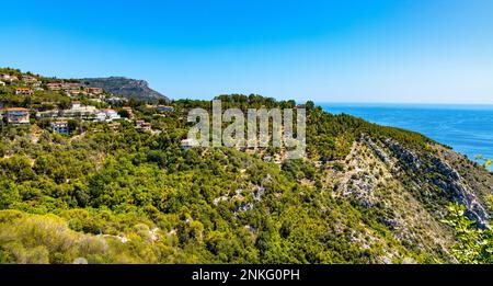 Eze, Frankreich - 1. August 2022: Panoramablick auf das Tal der Stadt Eze inmitten der Alpenhügel und des Wohngebiets mit Sommerhäusern und Villen an der französischen Riviera Stockfoto