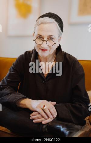 Lächelnde ältere Frau mit Brille zu Hause Stockfoto