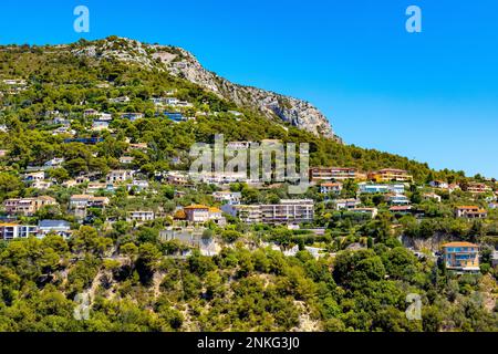 Eze, Frankreich - 1. August 2022: Panoramablick auf das Tal der Stadt Eze inmitten der Alpenhügel und des Wohngebiets mit Sommerhäusern und Villen an der französischen Riviera Stockfoto