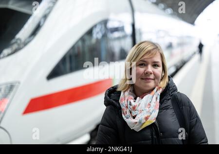 PRODUKTION - 21. Februar 2023, Sachsen, Leipzig: Ukrainische Inessa Orel steht neben einem EISZUG am Leipziger Hauptbahnhof. Die 34-jährige Anwältin wurde in Kiew geboren und lebte dort bei ihrer Familie, bis sie und ihre Kinder aus dem Krieg fliehen mussten. Über das Beratungszentrum „Job-Welt“ der Deutschen Bahn in Leipzig hat sie nun eine Stelle als Zugleiterin gefunden. Ein Jahr nach dem Ausbruch des russischen Angriffskrieges gegen die Ukraine am 24. Februar 2022 und etwa acht Monate nach der Eröffnung des Beratungszentrums haben die Mitarebiter etwa 1900 Beratungssitzungen durchgeführt. 26 Beschäftigungen bei Stockfoto