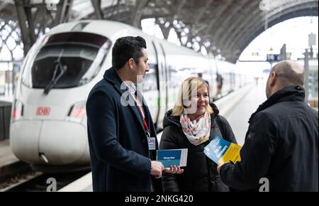 PRODUKTION – 21. Februar 2023, Sachsen, Leipzig: Kamran Radzhput (l) aus der Ukraine und Viktor Omelianenko von der Job World der Deutschen Bahn sprechen mit Inessa Orel am Leipziger Hauptbahnhof. Die 34-jährige Mutter und Anwältin aus Kiew hatten über Job-Welt einen Job in der Eisenbahnabteilung gefunden. Das Beratungszentrum in Leipzig soll neue Mitarbeiter für die Eisenbahn einstellen. Im September letzten Jahres wurde im Frankfurter Hauptbahnhof eine weitere eröffnet. Mobile Teams sind in Köln und Berlin unterwegs. Ein Jahr nach dem Ausbruch des russischen Angriffskriegs gegen die Ukraine am Februar Stockfoto