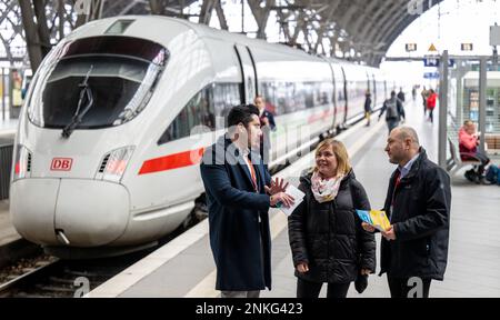 PRODUKTION – 21. Februar 2023, Sachsen, Leipzig: Kamran Radzhput (l) aus der Ukraine und Viktor Omelianenko von der Job World der Deutschen Bahn sprechen mit Inessa Orel am Leipziger Hauptbahnhof. Die 34-jährige Mutter und Anwältin aus Kiew hatten über Job-Welt einen Job in der Eisenbahnabteilung gefunden. Das Beratungszentrum in Leipzig soll neue Mitarbeiter für die Eisenbahn einstellen. Im September letzten Jahres wurde im Frankfurter Hauptbahnhof eine weitere eröffnet. Mobile Teams sind in Köln und Berlin unterwegs. Ein Jahr nach dem Ausbruch des russischen Angriffskriegs gegen die Ukraine am Februar Stockfoto