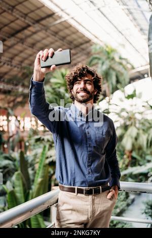 Glücklicher Geschäftsmann, der Selfie über sein Smartphone macht Stockfoto