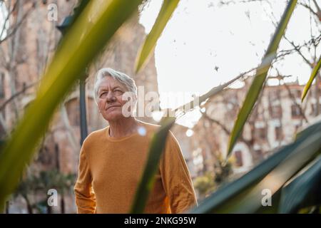 Rücksichtsvoller Senior-Mann, der vor dem Gebäude steht Stockfoto