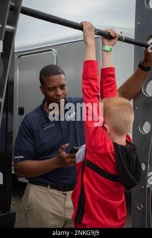 Hauptfeldwebel Efrem Swoope, Rekrutierungsoffizier für den 179. Luftwaffenflügel, spricht über seine Erfahrung in der Air National Guard, während er den Krafttest in einem Rekrutierungszelt der Air National Guard beim Requests and Pistons Festival in Akron, Ohio, am 14. August 2022 durchführte. MSgt Swoope glaubt, dass der größte Vorteil der Arbeit bei der Air National Guard die Kultur ist, die unsere Mitglieder geschaffen haben, während sie sich um einander und die lokale Gemeinschaft kümmern. Stockfoto
