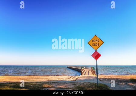 Straßenschild mit Text „Road Ends“ vor dem Pier, Lake Huron, Michigan, USA Stockfoto