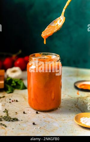 Frische hausgemachte Tomatensauce im Glas auf dem Tisch Stockfoto