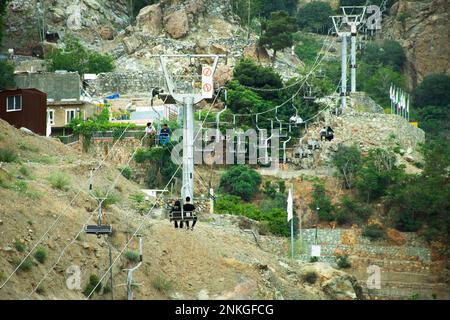 Teheran, Iran-28. Mai 2022: Touristen sitzen in der Seilbahn und fahren zum Aussichtspunkt im Norden von Teheran. Beliebte Sehenswürdigkeit bei Einheimischen und Touristen. Stockfoto