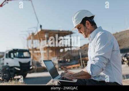 Architekt mit Laptop auf Baustelle Stockfoto
