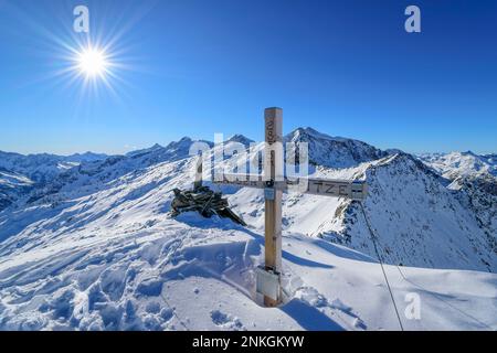 Österreich, Tirol, die Sonne scheint über dem Gipfelkreuz in den Zillertalalpen Stockfoto