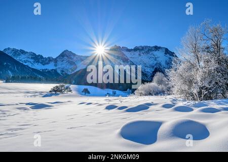 Deutschland, Bayern, Sonnenaufgang über dem schneebedeckten See in den Bayerischen Alpen Stockfoto