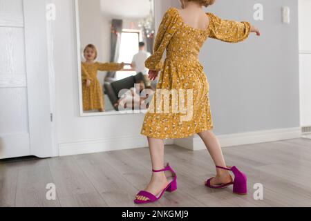 Ein Mädchen in Mutterschuhen, das zu Hause vor dem Spiegel tanzt Stockfoto