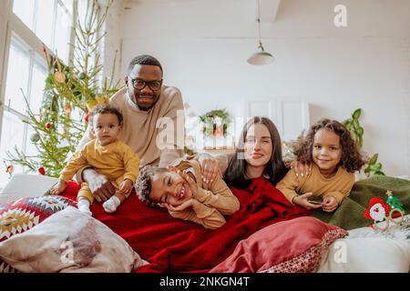 Glückliche Eltern mit Töchtern und Sohn, die Weihnachten genießen Stockfoto