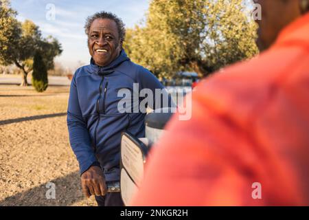 Ein glückliches Paar, das im Park mit den Fitnessgeräten im Freien trainiert Stockfoto