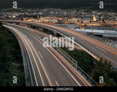 Österreich, Lichtstraßen, die sich in der Abenddämmerung entlang der erhöhten Autobahn erstrecken Stockfoto