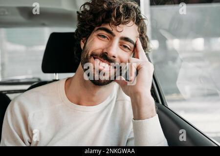 Glücklicher junger Mann, der im Auto reist Stockfoto