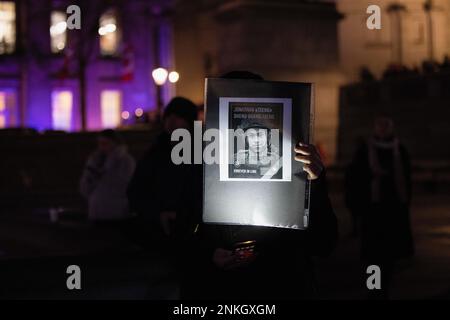 London, Großbritannien. 23. Februar 2023. Ein Unterstützer hält ein Foto von Sheng-guangTseng, einem taiwanesischen Militärveteran, der der erste Soldat der Internationalen Legion für territoriale Verteidigung der Ukraine aus Ostasien war, der während des russisch-ukrainischen Krieges bei der Kundgebung am Trafalgar Square im Einsatz getötet wurde. DIE US-Botschaft London und die Botschaft der Ukraine in Großbritannien haben sich am Vorabend des 1.-jährigen Bestehens des Russisch-Ukraine-Krieges gemeinsam an einer Kundgebung am Trafalgar Square in London mit der Ukraine beteiligt. Kredit: SOPA Images Limited/Alamy Live News Stockfoto