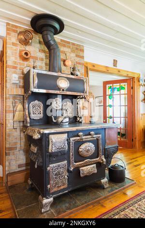 1913 McClary Famous Kootenay Range Holzofen im Speisesaal im alten, ca. 1840 erbauten Haus. Stockfoto