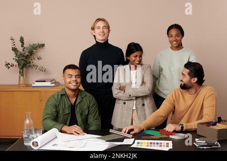 Fröhliche Modedesigner am Arbeitsplatz Stockfoto