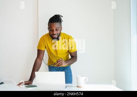 Freiberufler, der im Home Office arbeitet, mit Laptop auf dem Schreibtisch Stockfoto