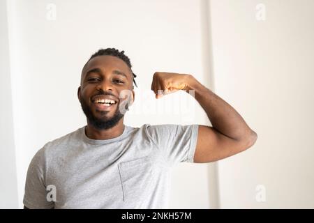 Mann, der Muskeln vor der Wand beugt Stockfoto