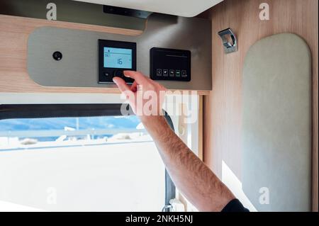 Hand des Mannes, die die AC-Temperatur im Wohnmobil anpasst Stockfoto