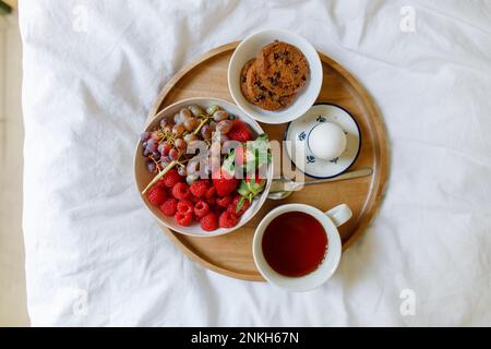 Frühstück auf einem Holztablett im Bett zu Hause Stockfoto