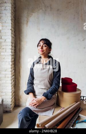 Lächelnde Frau sitzen am Schreibtisch Stockfoto