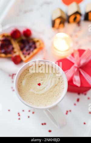 Kaffee mit Frühstück und herzförmige Geschenkbox Stockfoto