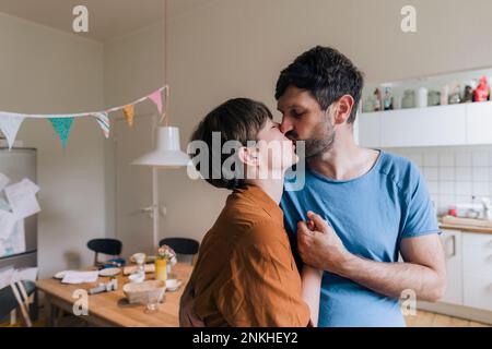 Liebevolles Paar, das sich zu Hause küsst Stockfoto