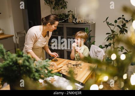 Glückliche Mutter und Sohn, die zu Hause Weihnachtskekse machen Stockfoto