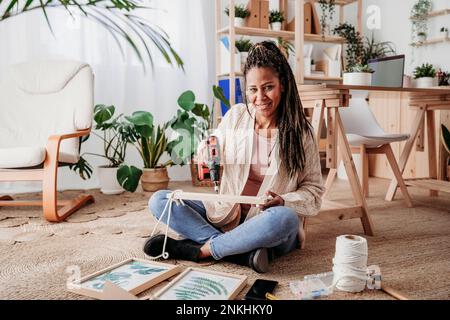 Eine Frau, die zu Hause ein Heimwerkerregal macht Stockfoto