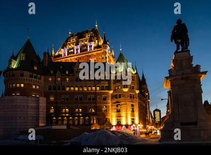 Nachtfoto des historischen Fairmont Le Chateau Frontenac in der Oberstadt des historischen Viertels, mit der Statue von Samuel-De Champlain im Vordergrund. Stockfoto