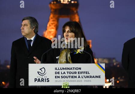 Paris, Frankreich, 23. Februar 2023. Die Pariser Bürgermeisterin Anne Hidalgo (C) spricht ein Jahr, nachdem Russland eine Militärinvasion in das Land eingeleitet hatte, während einer Veranstaltung, bei der der ukrainische Eifelturm in den Farben der ukrainischen Flagge beleuchtet und damit die Ukraine unterstützt wurde, ein Jahr nach Beginn der russischen Militärinvasion des Landes in Paris, vom ukrainischen Botschafter in Frankreich Vadym Omelchenko (L). Frankreich am 23. Februar 2023. Kiew wird am 24. Februar anlässlich des ersten Jahrestages der Moskauer Invasion angesetzt, als sich die Ukrainer nach einem Jahr der Trotz und Trauer auf mögliche neue russische Streiks freuten, da der russische Präsident vor einem Jahr die Welt betäubte, indem er Truppen über den Hafen schickte Stockfoto