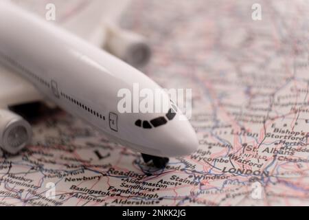 Nahaufnahme eines Miniatur-Passagierflugzeugs auf einer detaillierten Karte, die London, England, durch selektiven Fokus, Hintergrundunschärfe hervorhebt Stockfoto