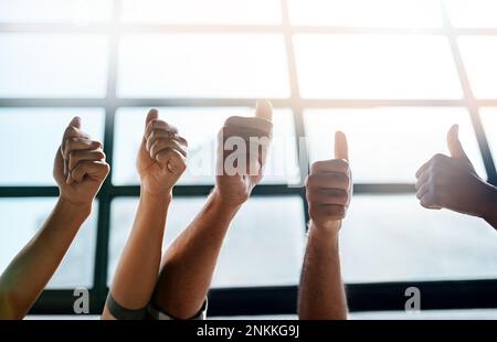 Das ist ein überwältigendes Ja von uns allen. Eine Gruppe von unbekannten Geschäftsleuten, die die Daumen nach oben drücken. Stockfoto