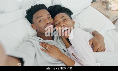 Selfie und glückliches Influencer-Paar, das ihre Flitterwochen im Bett bucht, um zu Hause zu lieben und zu entspannen. Porträt eines liebenden schwarzen Mannes und Stockfoto