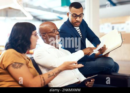 Auf diesen einen Aspekt müssen wir uns konzentrieren. Eine Gruppe von Designern, die eine Diskussion in einem Büro führen. Stockfoto