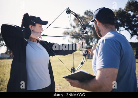 Bogenschießen, Pfeil und Bogen mit Frau und Trainer, Zielen mit Sport im Freien, Kampftraining und Waffe. Coaching, Lernen und Lehren mit Stockfoto