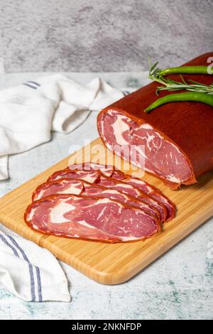 Rinderribeye Pastrami. Getrocknete türkische Speckscheibe auf Holzbrett. Traditionelle türkische Köstlichkeiten. Lokaler Name Cemenli pastirma Stockfoto