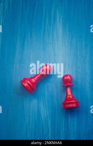 Zwei rote Schachfiguren vor blauem Hintergrund Stockfoto