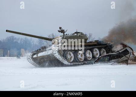 KRASNOYE SELO, RUSSLAND - 19. FEBRUAR 2023: Ein sowjetischer Panzer T-54 zerquetschte einen Pkw. Fragmente einer Panzershow im historischen Militärpark "Steel" Stockfoto