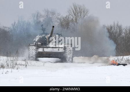 KRASNOYE SELO, RUSSLAND - 19. FEBRUAR 2023: Ein sowjetischer Panzer T-54 am Rande eines Waldes bei starkem Schneefall. Military Historical Park „Steel Landing“ Stockfoto