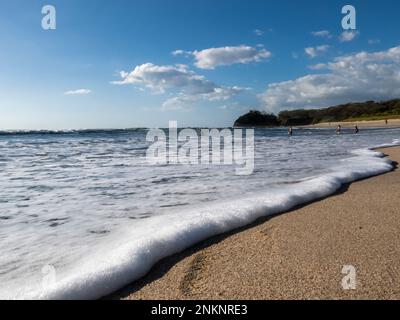 Blick aus einem tiefen Winkel auf die Wellen, die sich am Strand nahe Nosara in Costa Rica anschwemmen Stockfoto