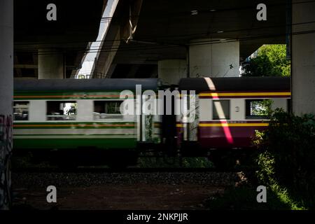 Lad Krabang, Thailand, 24/02/2023, Ein SRT-Zug (State Railway of Thailand) fährt unter einer Überführung in der Nähe des Bahnhofs Lad Krabang. Das tägliche Leben rund um Lad Krabang, ein Wohnviertel in der Nähe des internationalen Flughafens Suvarnabhumi, in East Bangkok, Thailand, am 24. Februar 2022. Stockfoto