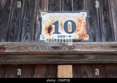 Hausnummer auf einer alten Holztür Stockfoto