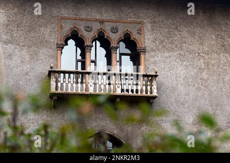 Verzierte gotische Fenster und Steinbalkon an einer Gebäudewand. Detail der historischen Architektur, Verona. Stockfoto